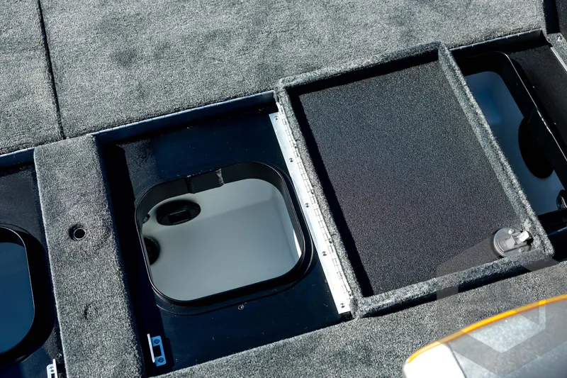 Slide: The Image of 2026 Skeeter ZXE20 boat storage compartments with carpeted lids and secure locks. - 73
