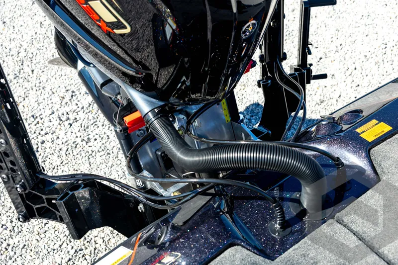 Slide: The Image of 2026 Skeeter ZXE20 boat engine detail with cables and components on gravel surface. - 77