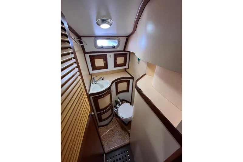 Slide: The Image of Compact bathroom in 1993 Med Marine Montevideo 43 yacht, featuring sink, toilet, and wooden accents. - 17