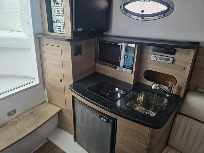 Slide: The Image of 2008 Donzi 38 ZSF boat interior with kitchenette, sink, microwave, and control panel. - 14