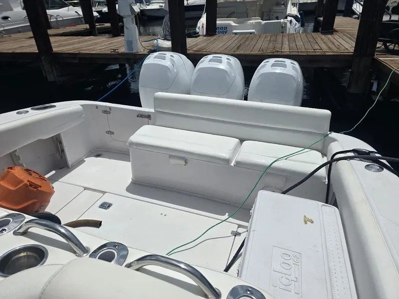 Slide: The Image of 2008 Donzi 38 ZSF boat interior with seating and triple outboard engines at dock. - 17