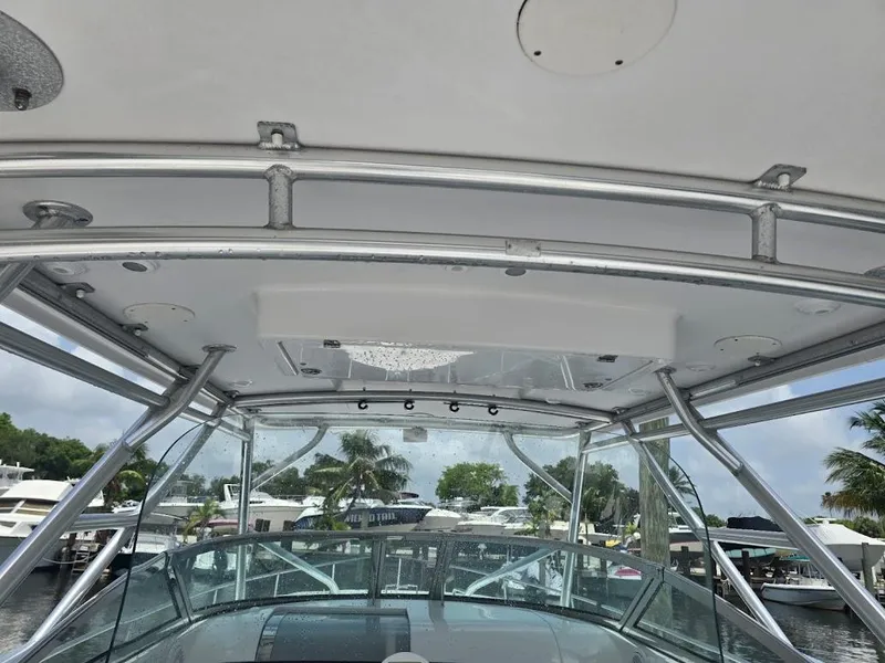 Slide: The Image of 2008 Donzi 38 ZSF boat with metal framework and clear canopy, docked near palm trees. - 7
