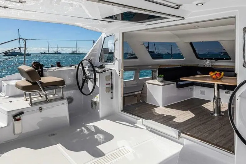 Slide: The Image of 2022 Seawind 1160 Lite catamaran interior with helm, seating, and ocean view. - 4