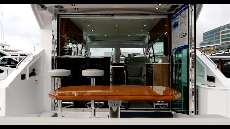 Slide: The Image of 2024 Cruisers Yachts 50 Cantius interior with bar stools and wooden table. - 26