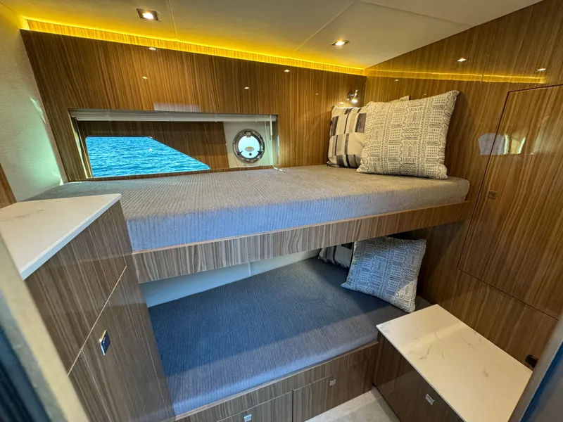 Slide: The Image of 2024 Cruisers Yachts 50 Cantius interior cabin with bunk beds and modern wood finish. - 21