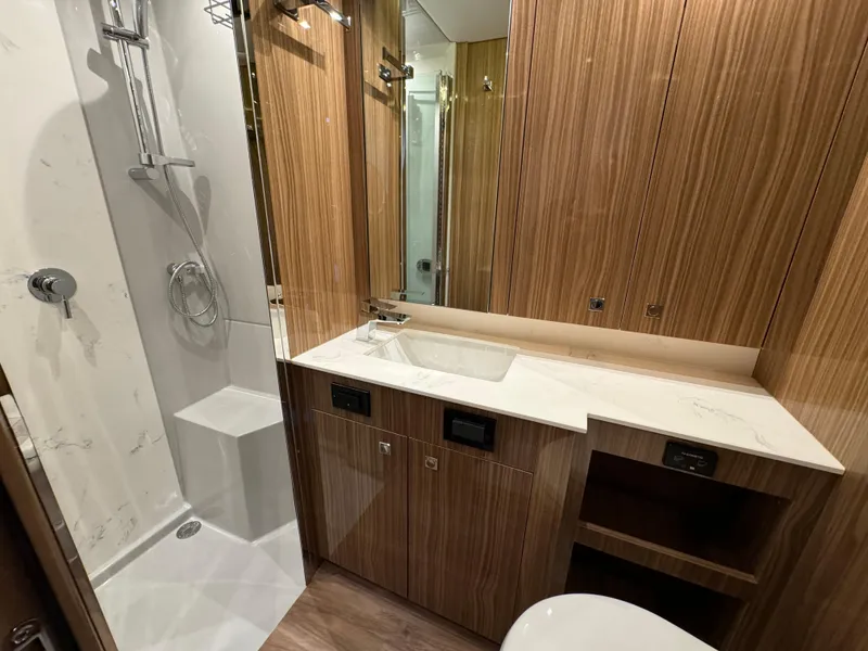 Slide: The Image of 2024 Cruisers Yachts 50 Cantius bathroom with modern shower and wooden cabinetry. - 22