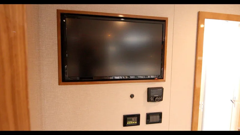Slide: The Image of 2024 Cruisers Yachts 50 Cantius interior with wall-mounted TV and control panels. - 44