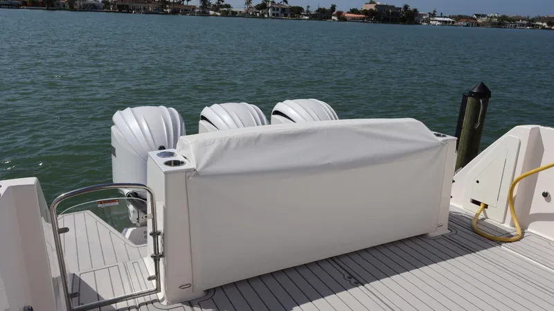Slide: The Image of 2022 Regal 38 SAV boat with covered outboard engines on a sunny day. - 12