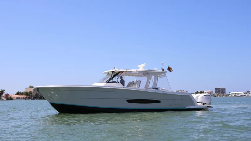 Slide: The Image of 2022 Regal 38 SAV boat cruising on calm waters under clear blue sky. - 2