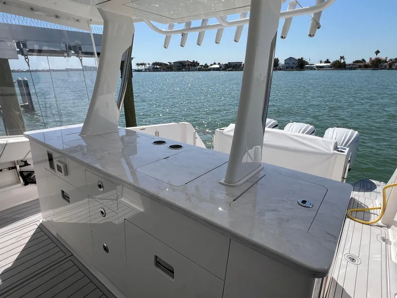 Slide: The Image of 2022 Regal 38 SAV yacht with sleek outdoor kitchen overlooking serene waterfront. - 28