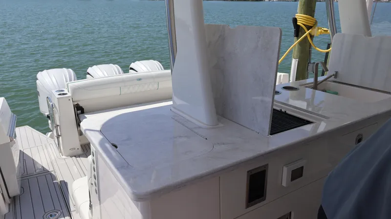 Slide: The Image of 2022 Regal 38 SAV boat with sleek deck and powerful outboard engines. - 29