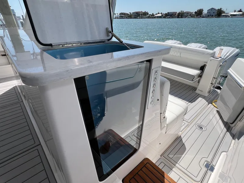 Slide: The Image of 2022 Regal 38 SAV yacht interior with open storage compartment, docked by the water. - 34