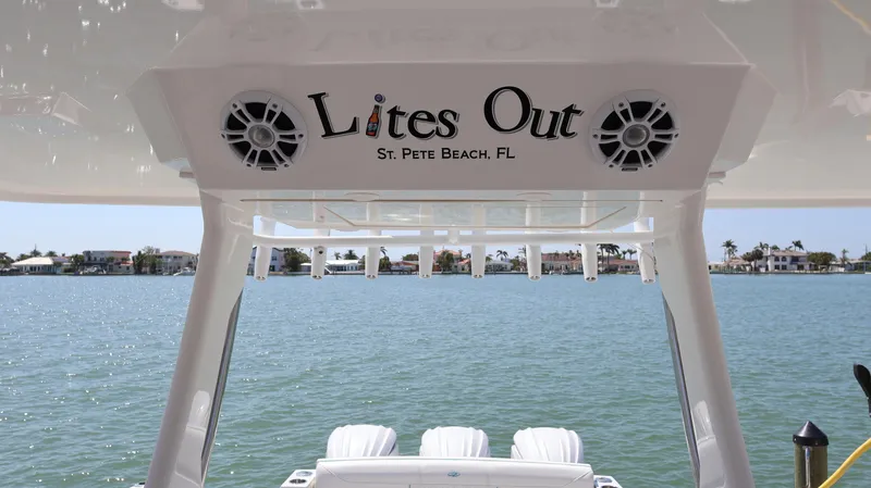 Slide: The Image of 2022 Regal 38 SAV boat with "Lites Out" sign, St. Pete Beach, FL, scenic water view. - 38