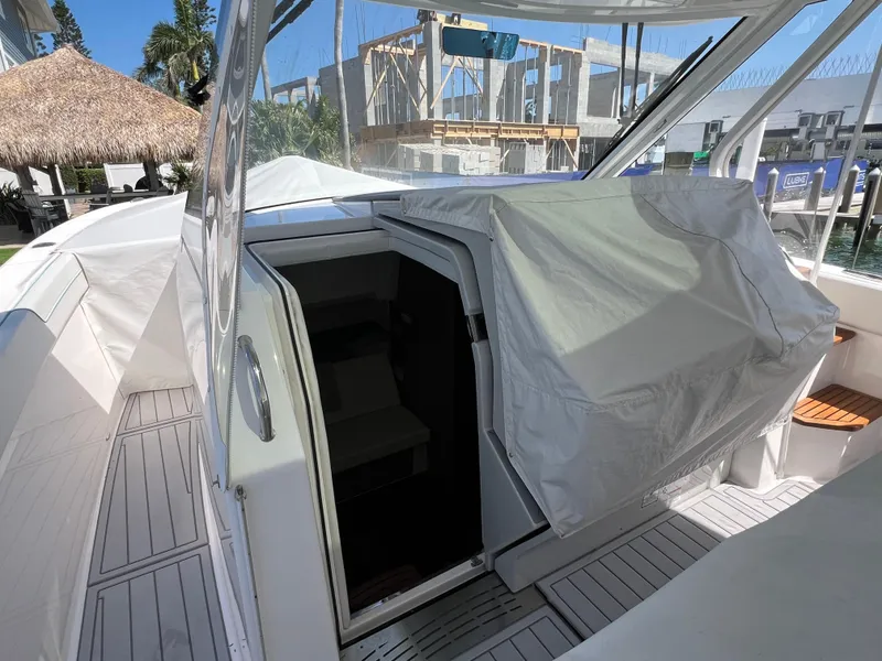 Slide: The Image of 2022 Regal 38 SAV boat with open cabin entrance, docked near a tropical setting. - 42