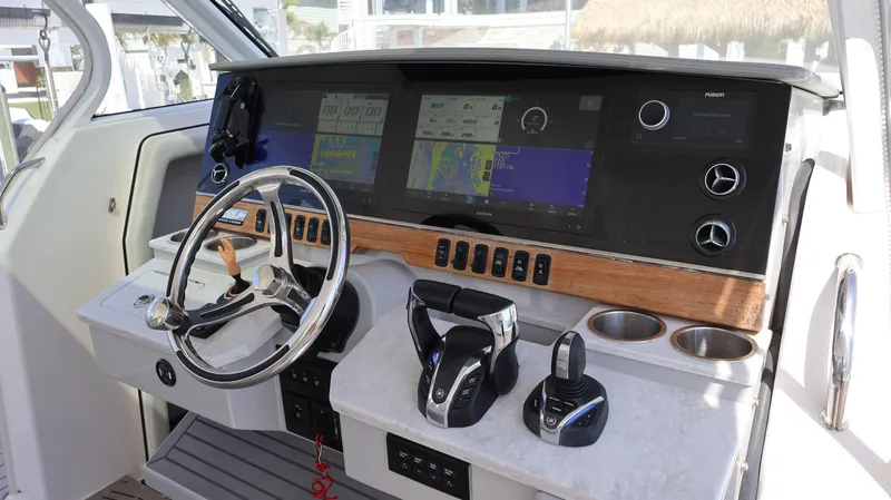 Slide: The Image of Cockpit of 2022 Regal 38 SAV boat with modern navigation controls and steering wheel. - 43