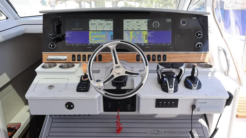 Slide: The Image of 2022 Regal 38 SAV boat dashboard with steering wheel and navigation screens. - 44