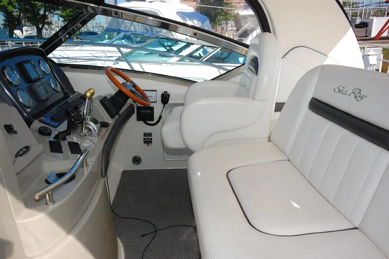 Slide: The Image of 2004 Sea Ray 390 Sundancer cockpit with white seating and control panel. - 10