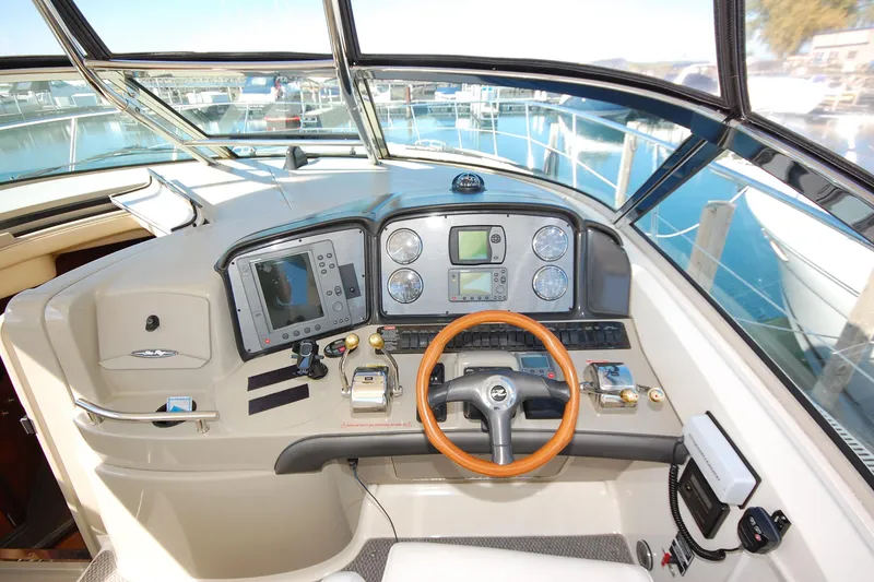 Slide: The Image of 2004 Sea Ray 390 Sundancer helm with navigation instruments and wooden steering wheel. - 11