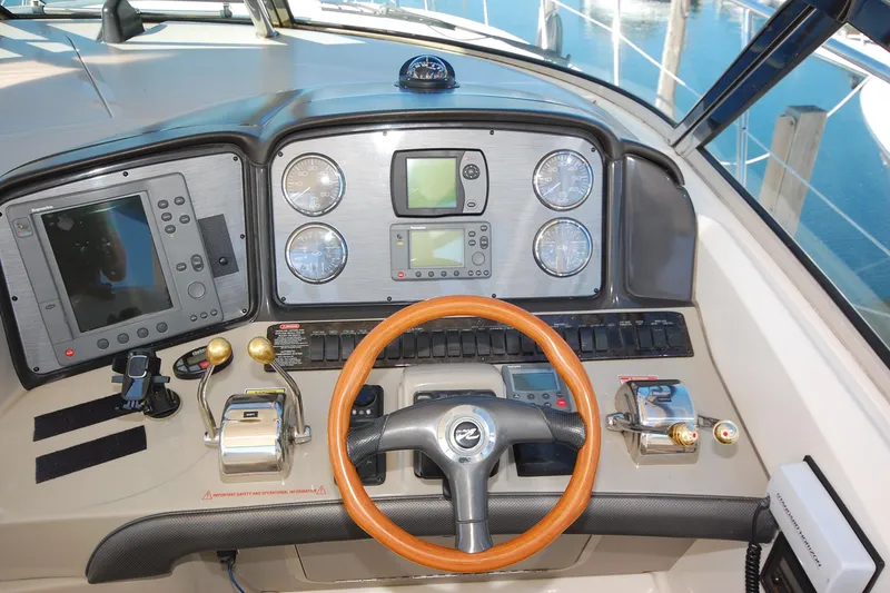 Slide: The Image of 2004 Sea Ray 390 Sundancer helm with navigation instruments and wooden steering wheel. - 12