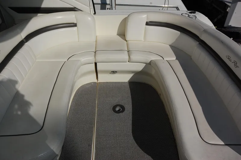 Slide: The Image of 2004 Sea Ray 390 Sundancer boat interior with white cushioned seating. - 13