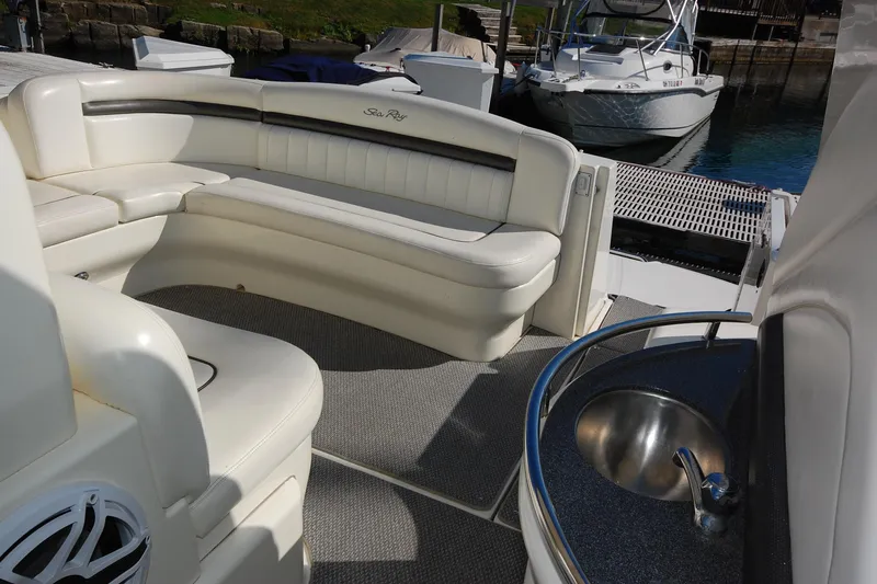 Slide: The Image of 2004 Sea Ray 390 Sundancer interior with white seating and a small sink. - 14