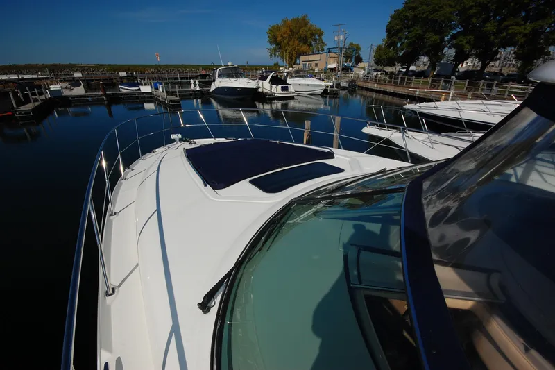 Slide: The Image of 2004 Sea Ray 390 Sundancer yacht docked at a marina under clear blue skies. - 18