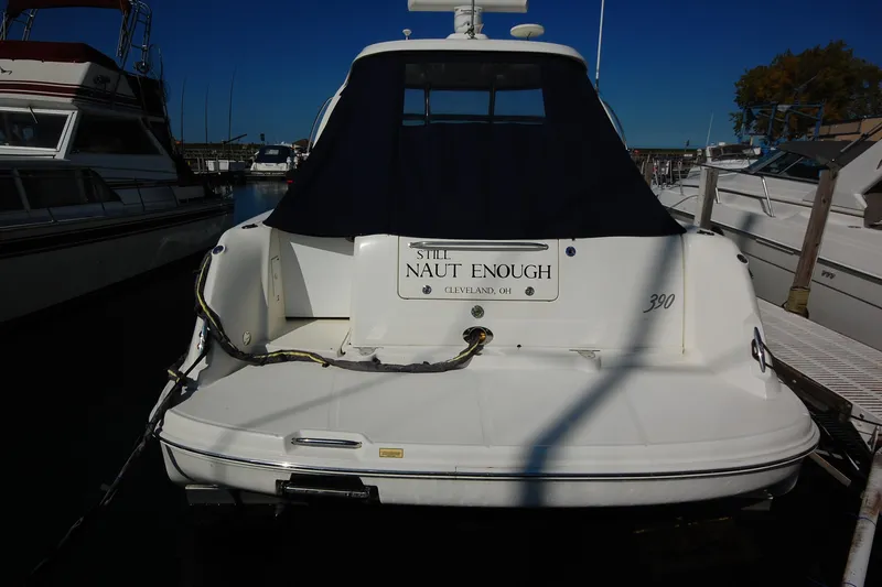 Slide: The Image of 2004 Sea Ray 390 Sundancer docked, rear view with cover, "Still Naut Enough" sign. - 6