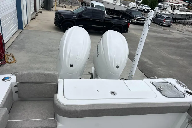 Slide: The Image of 2025 Sea Hunt Gamefish 27 boat with dual engines, parked near black truck. - 5