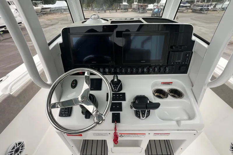 Slide: The Image of 2025 Sea Hunt Gamefish 27 Forward Seating helm with advanced controls and navigation displays. - 7