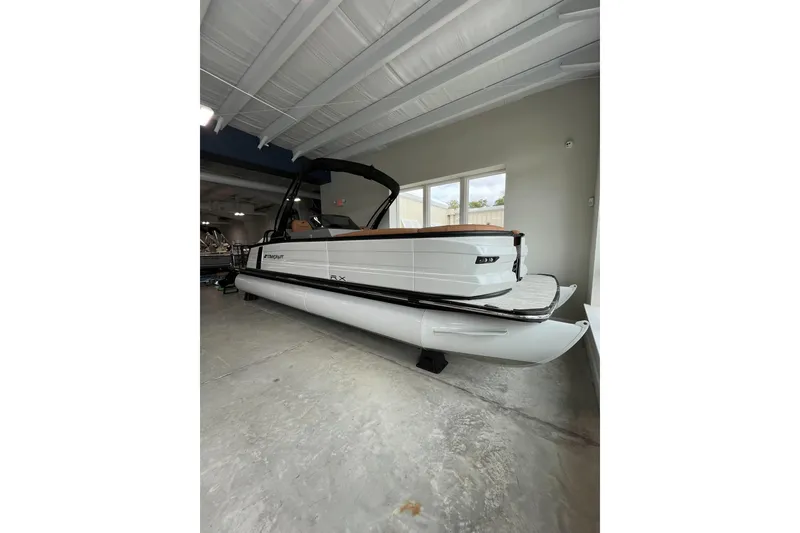 Slide: The Image of 2026 Starcraft RX 25 DL DC pontoon boat in showroom, side view. - 2