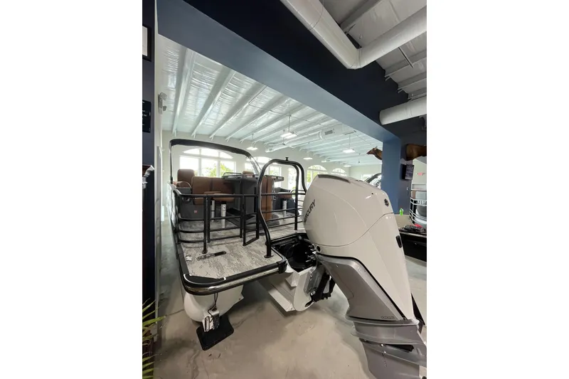 Slide: The Image of 2026 Starcraft RX 25 DL DC boat with powerful outboard motor in showroom. - 3