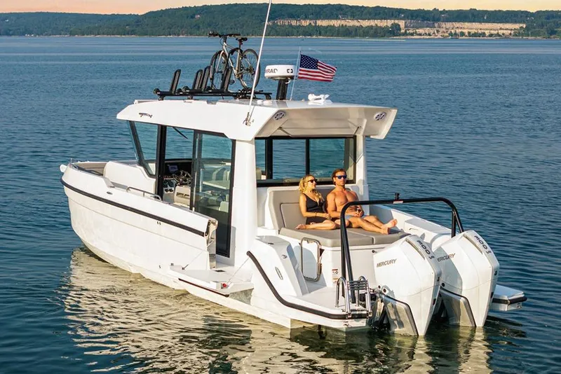 Slide: The Image of 2026 Cruisers Yachts 38 VTR on serene water, featuring dual Mercury engines and rooftop bikes. - 2