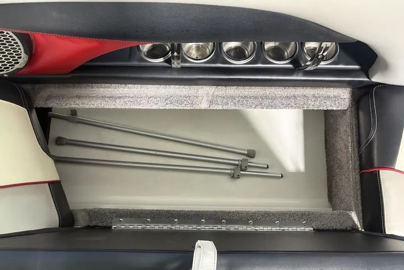 Slide: The Image of Storage compartment in 2015 Malibu Wakesetter 247 LSV boat with cup holders and metal rods. - 11