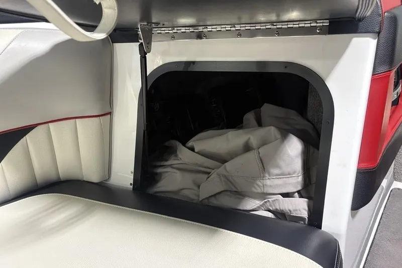 Slide: The Image of Storage compartment in 2015 Malibu Wakesetter 247 LSV boat with white and red interior. - 18