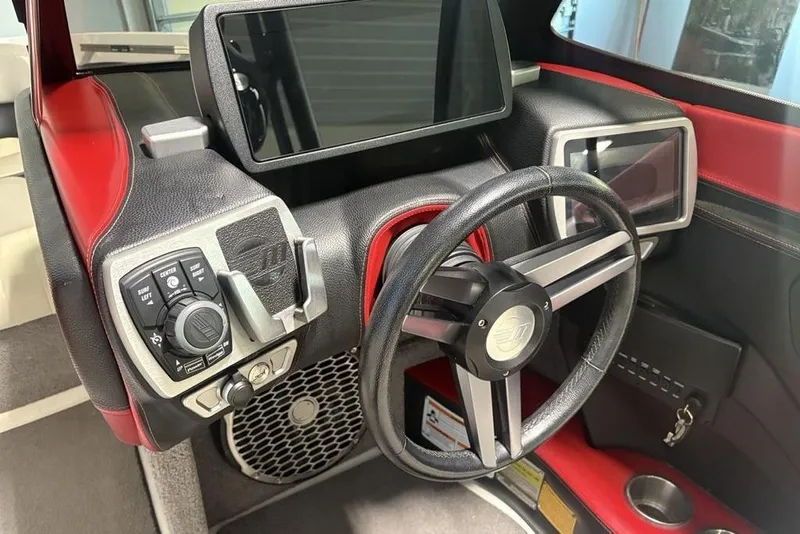 Slide: The Image of 2015 Malibu Wakesetter 247 LSV dashboard with steering wheel and control panel. - 22