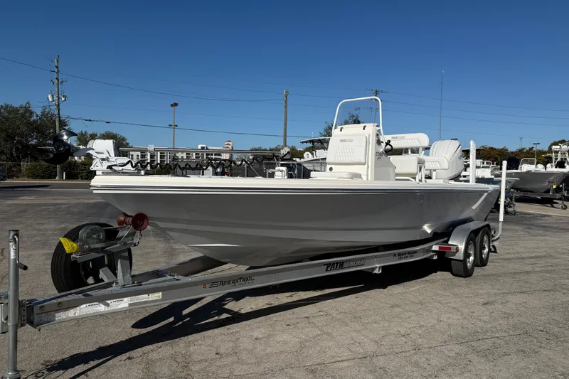 The Image of 2026 Pathfinder 2300 HPS boat on trailer, parked outdoors under clear blue sky. - 0