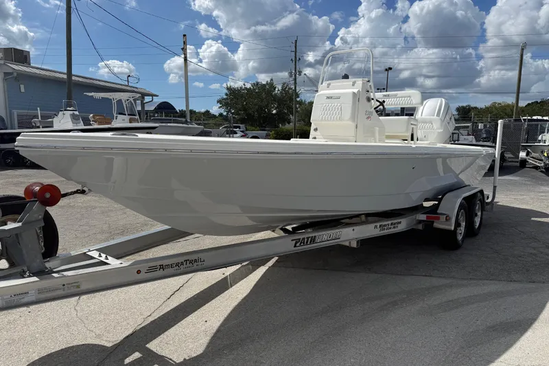 Slide: The Image of 2026 Pathfinder 2300 HPS boat on trailer, displayed outdoors under clear blue sky. - 2