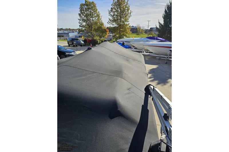 Slide: The Image of Covered 2022 Bennington SX 21 Fishing boat in a parking area with other boats. - 115