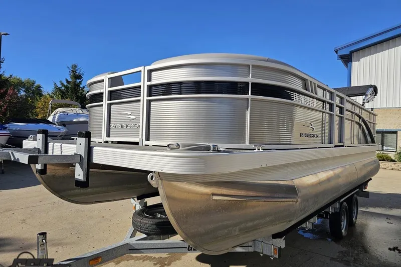 Slide: The Image of 2022 Bennington SX 21 Fishing pontoon boat on trailer, parked outdoors. - 19