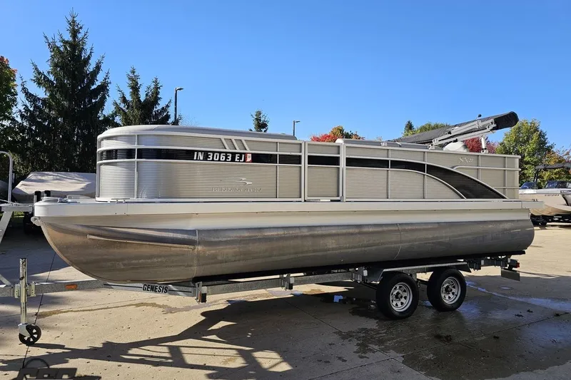 Slide: The Image of 2022 Bennington SX 21 Fishing pontoon boat on trailer, parked outdoors. - 21