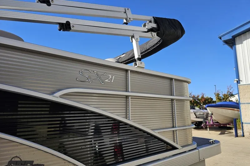 Slide: The Image of 2022 Bennington SX 21 Fishing boat, sleek design, docked under clear blue sky. - 25