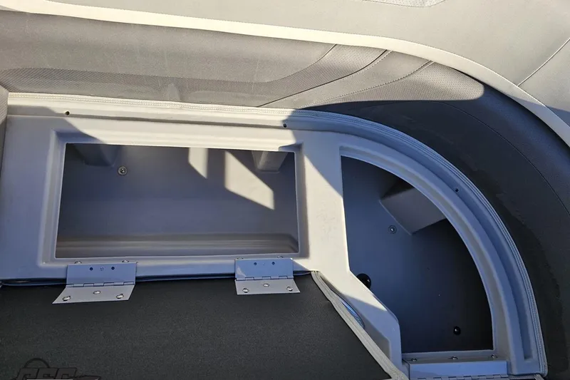 Slide: The Image of 2022 Bennington SX 21 Fishing boat storage compartment with open lid, showcasing interior space. - 87