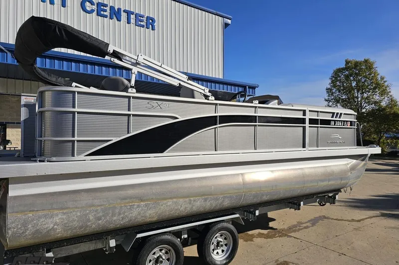 Slide: The Image of 2022 Bennington SX 21 Fishing pontoon boat on trailer outside a marine center. - 9