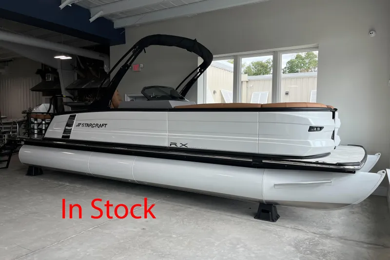 The Image of 2026 Starcraft RX 25 DL DC pontoon boat in showroom, labeled "In Stock." - 0