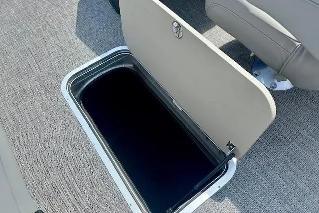 Slide: The Image of Storage compartment on 2026 Barletta A22QC boat with open hatch and carpeted floor. - 7