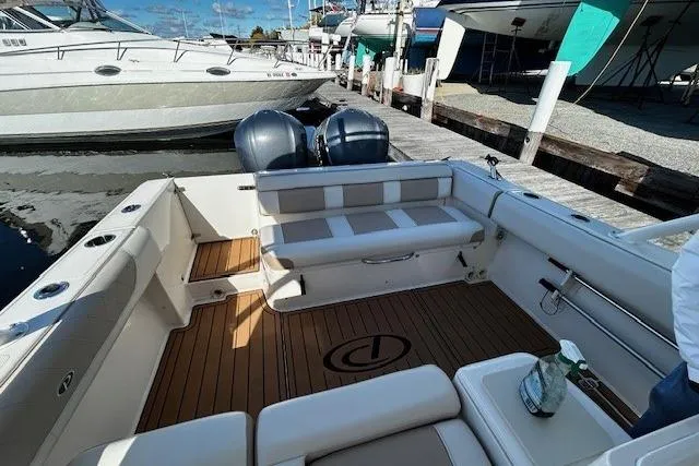 Slide: The Image of 2014 Pursuit ST 310 Sport boat interior with twin engines, docked at marina. - 12