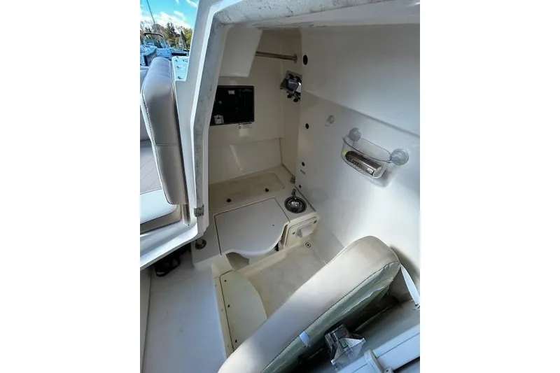 Slide: The Image of Interior cabin of a 2014 Pursuit ST 310 Sport boat, featuring seating and storage. - 13