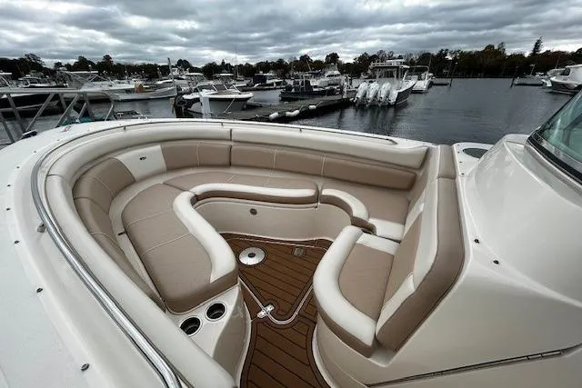Slide: The Image of 2014 Pursuit ST 310 Sport boat with spacious seating, docked at a marina under cloudy skies. - 15