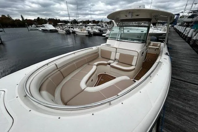 Slide: The Image of 2014 Pursuit ST 310 Sport boat docked, featuring spacious seating and sleek design. - 16