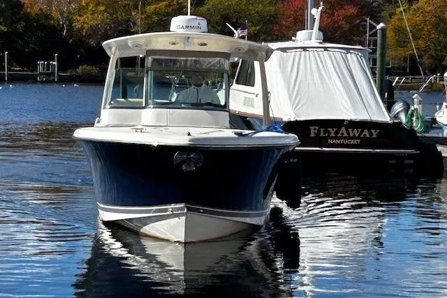 Slide: The Image of 2014 Pursuit ST 310 Sport boat docked on calm water. - 3